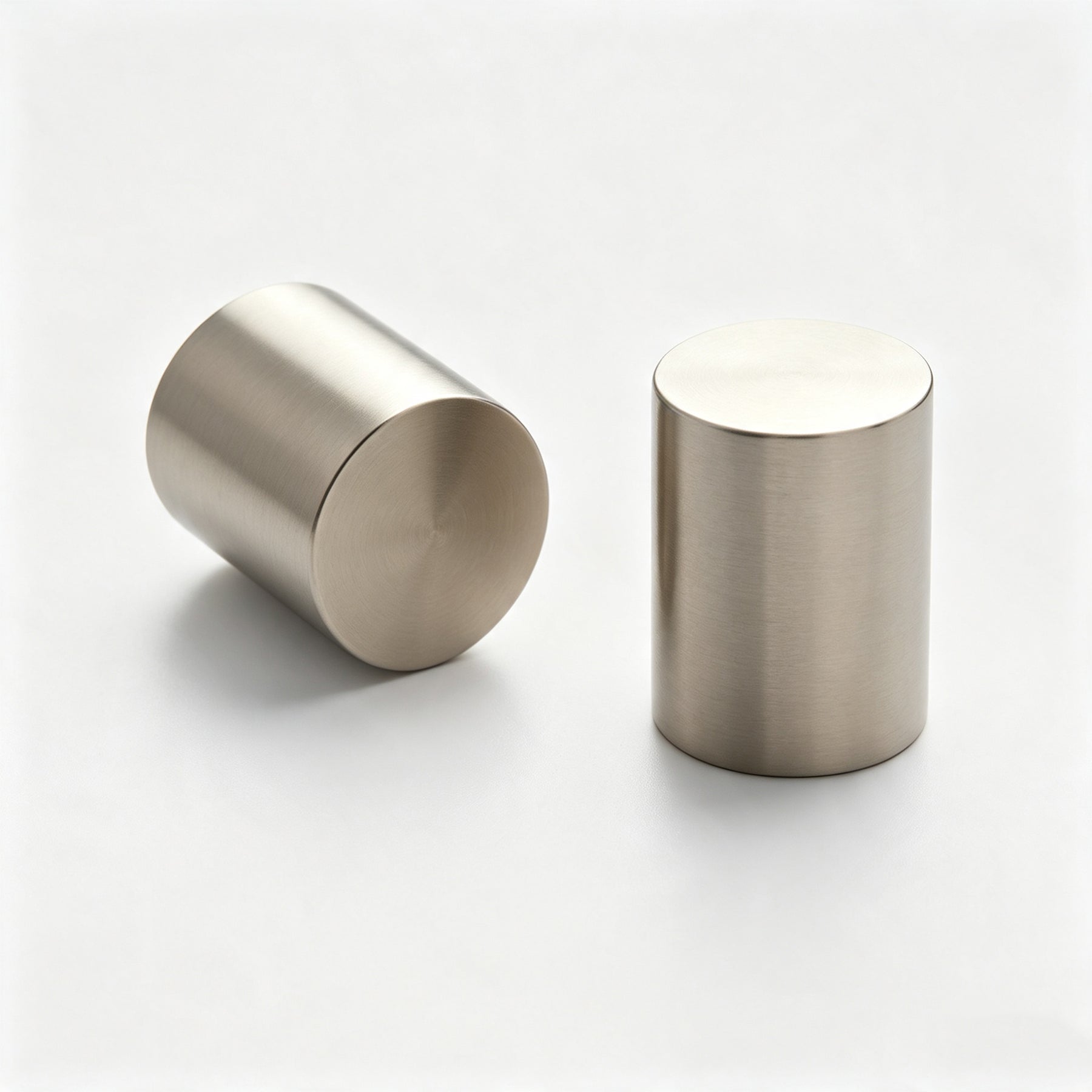 Silver-tone cylindrical cabinet knobs on a white background