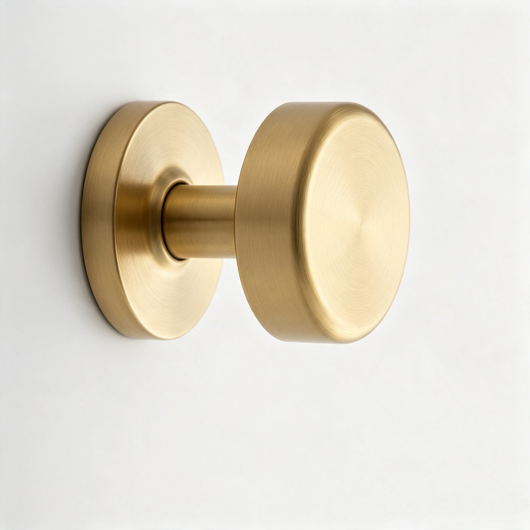 Warm metallic round cabinet knob on a white background
